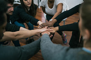 team of work showing unity with their hand togethe GAKTZ4N